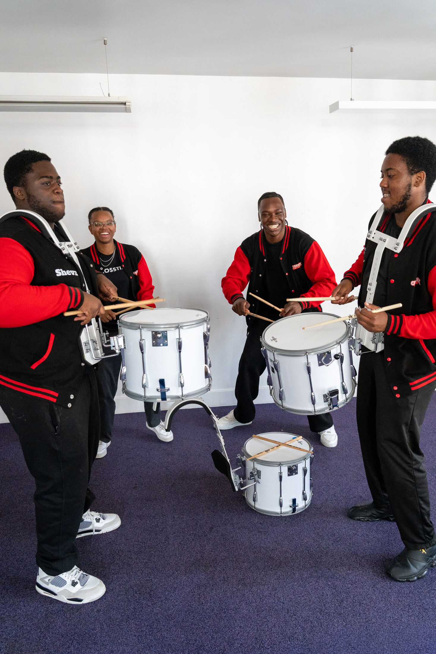 Academy members rehearsing with snare drums in a training room